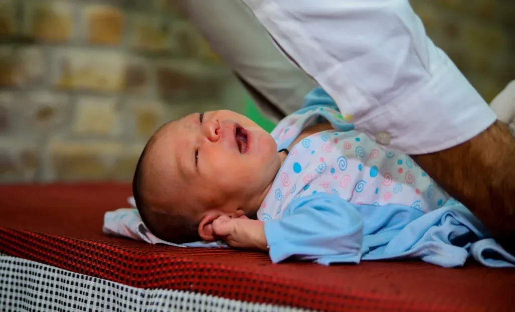 a baby lying on a person's lap